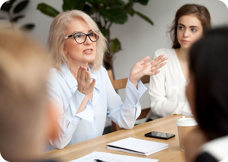 Woman speaking in a meeting setting.