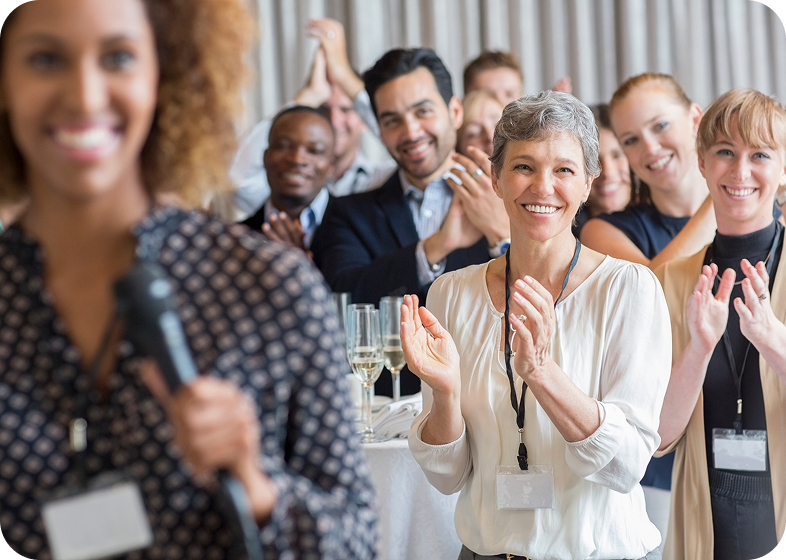 Audience applauding speaker at a conference.