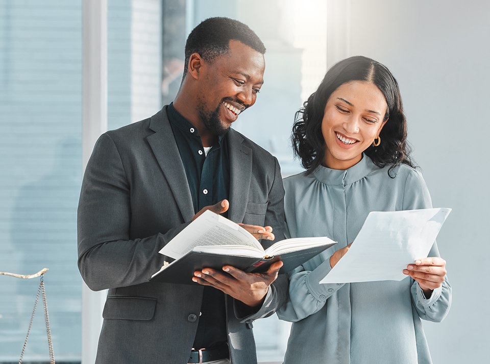 Man and woman reviewing documents together, smiling.